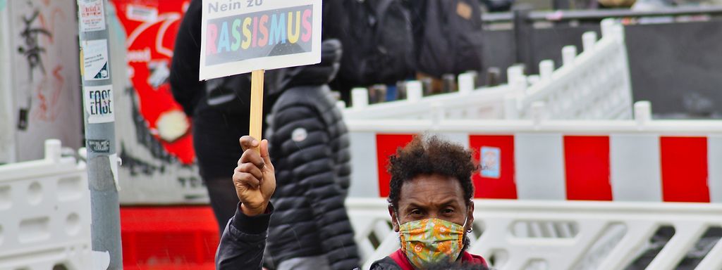 Menschen protestieren mit Schildern auf der Straße gegen Rassismus